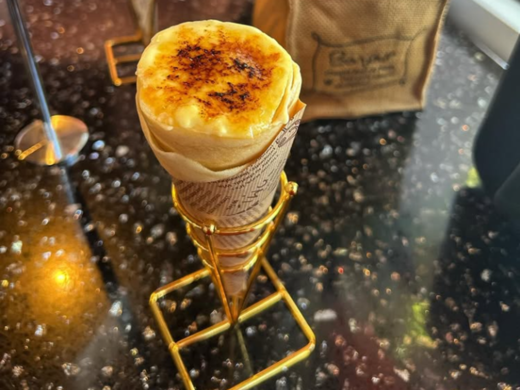 A delicious crème brûlée crepe with a caramelized sugar topping, filled with creamy custard and wrapped in a golden, thin crepe.