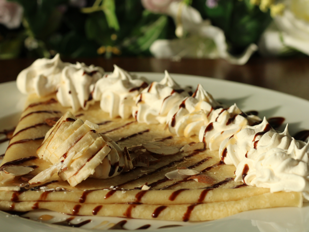 A rich and nutty crepe filled with almond butter, Nutella, sliced almonds, and fresh banana, folded to perfection and topped with a touch of sweetness.