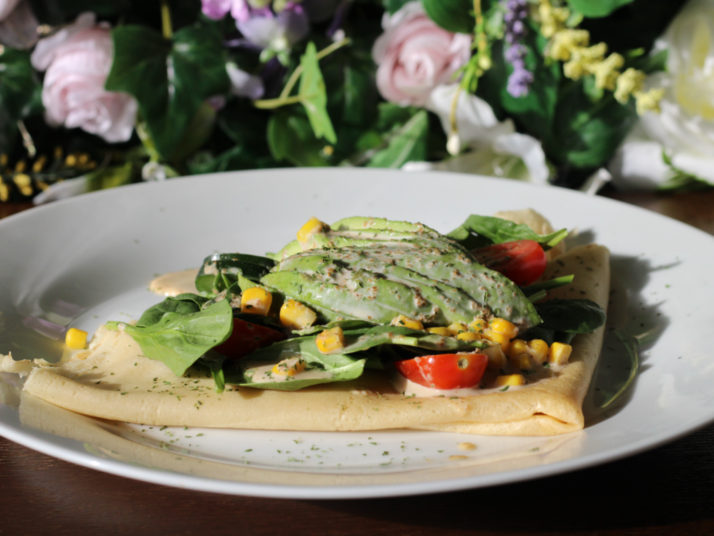 A fresh and flavorful vegetarian crepe filled with creamy avocado, crisp vegetables, and a light sesame dressing, wrapped in a golden crepe.